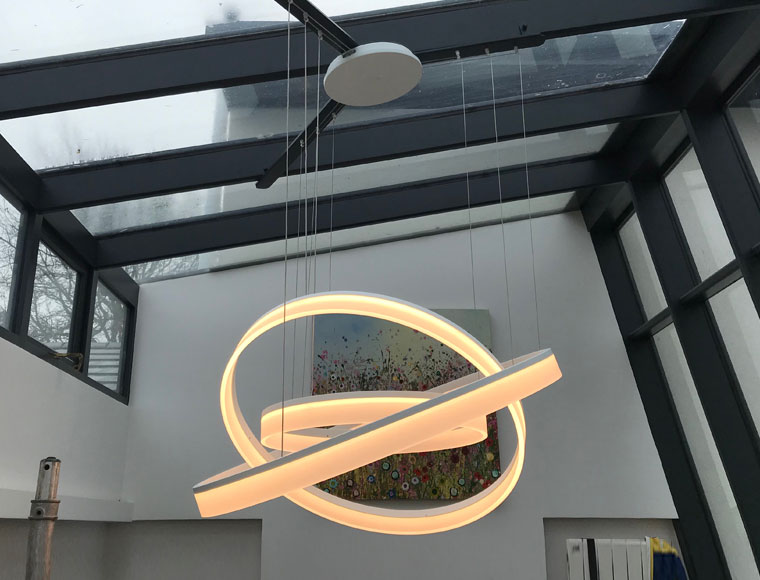 Multi-ring pendant illuminated over dining table
